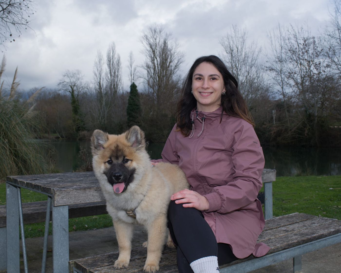Erine et son Eurasier Aslan, assis au bord de l'eau